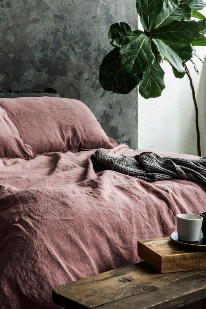 Stonewashed French Linen Duvet Cover Set in Woodrose with Raw Industrial Concrete Backdrop.