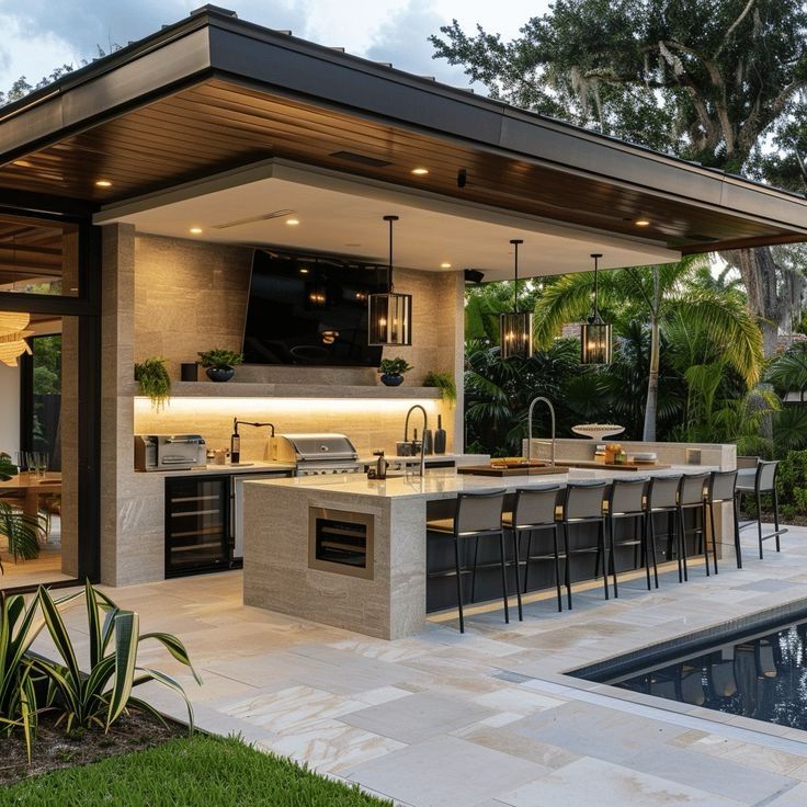 Modern Outdoor Kitchen with Pergola and Warm Pendant Lighting.