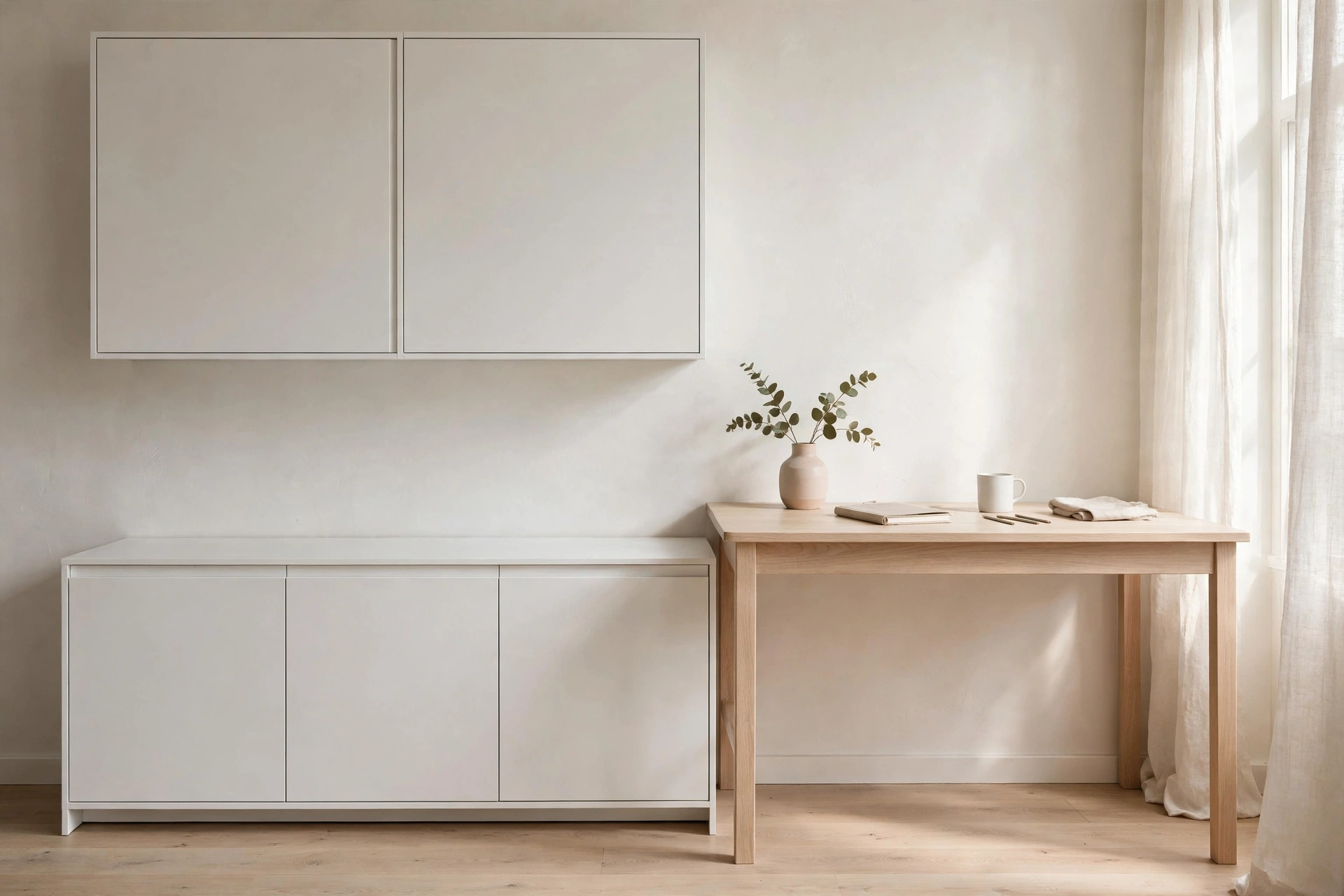 White matte sideboard and wall cabinets keeping a Scandinavian home office clutter-free